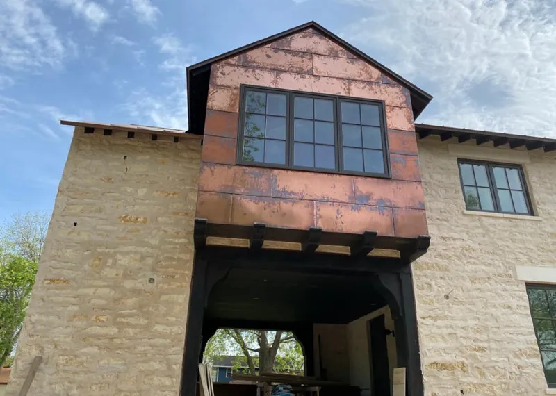 Copper metal panel facade on a stone building for Metal Roof Coating in Cinco Ranch